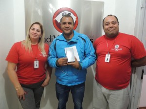 Rudnei Dutra de Abreu, ao centro, que recebeu um smartphone, com a diretora Cristilorem e o diretor Jéferson Vieira da Silva